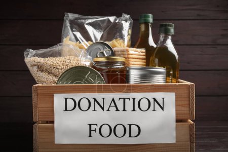 Photo for Donation crate with food on wooden background, closeup - Royalty Free Image