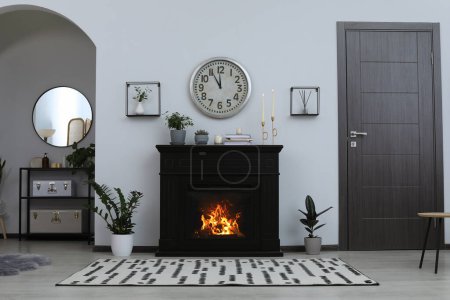 Photo for Stylish living room interior with fireplace and green plants - Royalty Free Image