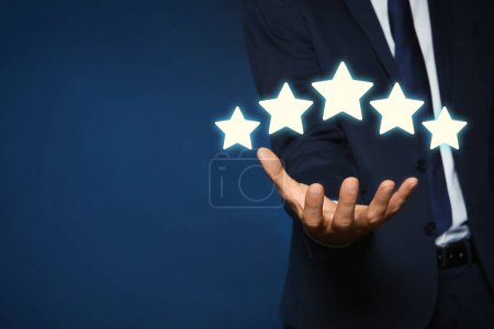 Man showing icons of five stars on blue background, closeup. Quality rating