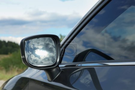 Foto de Nuevo coche moderno negro al aire libre, primer plano del espejo retrovisor lateral - Imagen libre de derechos