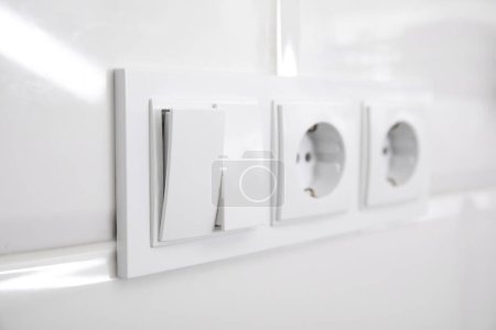 Foto de Interruptor de luz y tomas de corriente en la pared blanca en interiores, primer plano - Imagen libre de derechos