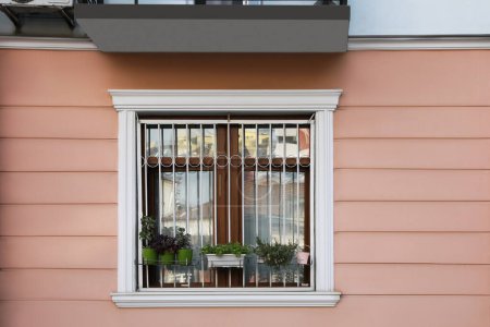 Foto de Hermosa ventana con parrillas y plantas en maceta en el edificio al aire libre - Imagen libre de derechos