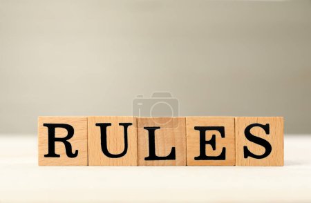 Word Rules made of cubes with letters on light wooden table