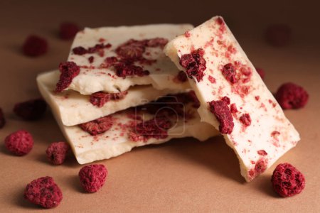 Photo for White chocolate with freeze dried raspberries on brown table, closeup - Royalty Free Image