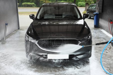 Téléchargez les photos : Lavage automatique avec jet d'eau haute pression au lavage de voiture extérieur - en image libre de droit