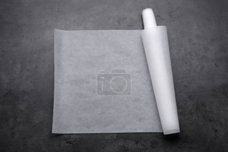 Foto de Rollo de papel para hornear sobre mesa gris, vista superior - Imagen libre de derechos