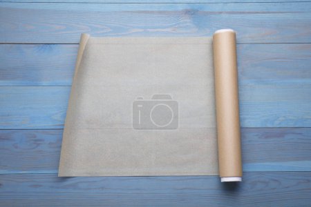 Téléchargez les photos : Rouleau de papier cuisson sur table en bois bleu clair, vue de dessus - en image libre de droit