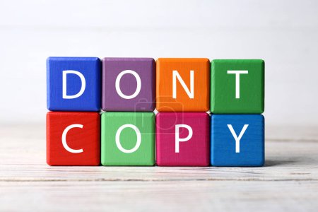 Téléchargez les photos : Cubes colorés avec des mots Ne pas copier sur une table en bois blanc, gros plan. Concept de plagiat - en image libre de droit