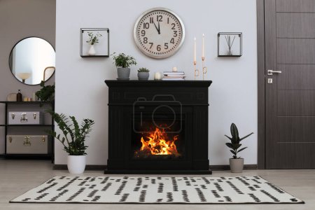 Photo for Stylish living room interior with fireplace and green plants - Royalty Free Image