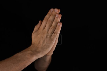 Foto de Hombre rezando sobre fondo negro, vista de cerca - Imagen libre de derechos
