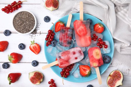 Foto de Composición plana con hielo de frutas y bayas sobre una mesa de madera blanca - Imagen libre de derechos