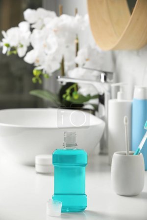 Foto de Botella de enjuague bucal en encimera blanca en el baño - Imagen libre de derechos