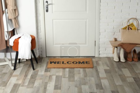 Foto de Felpudo con palabra Bienvenido en piso de madera en el pasillo - Imagen libre de derechos