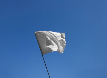 Foto de Bandera blanca ondeando contra el cielo azul en un día soleado - Imagen libre de derechos