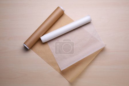 Téléchargez les photos : Rouleaux de papier cuisson sur table en bois, pose plate - en image libre de droit