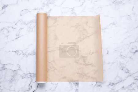 Téléchargez les photos : Rouleau de papier cuisson sur table en marbre blanc, vue de dessus - en image libre de droit