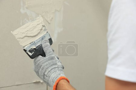 Photo for Worker plastering wall with putty knife, closeup - Royalty Free Image