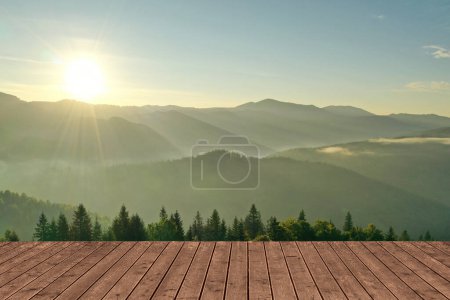 Superficie de madera vacía y hermosa vista del paisaje de montaña con bosque