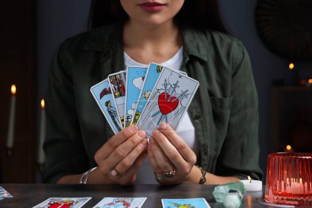 Cajero de la fortuna con cartas del tarot en la mesa gris en el interior, primer plano