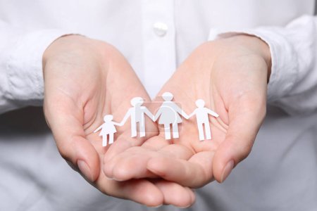 Photo for Woman holding paper family figures, closeup. Insurance concept - Royalty Free Image