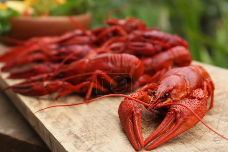Delicious red boiled crayfish on wooden table, closeup