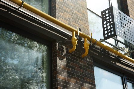 Foto de Tubo de gas amarillo cerca del edificio en zona residencial al aire libre - Imagen libre de derechos