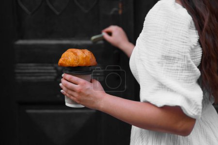 Téléchargez les photos : Femme avec porte ouvrant savoureux croissant, vue rapprochée - en image libre de droit