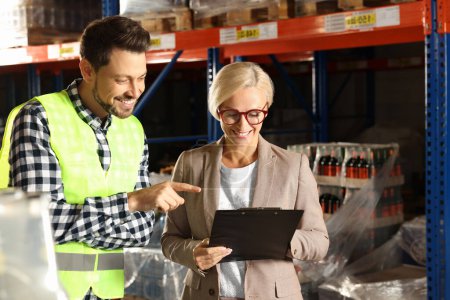 Photo for Manager and worker in warehouse with lots of products - Royalty Free Image