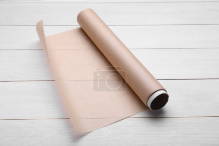 Téléchargez les photos : Rouleau de papier cuisson sur table en bois blanc - en image libre de droit