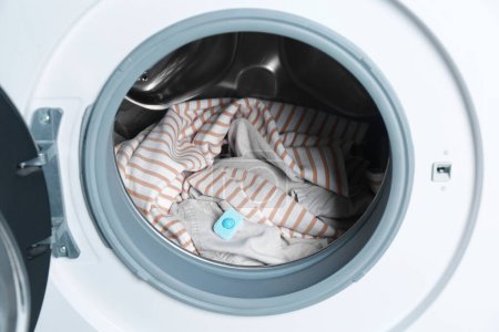 Photo for Water softener tablet on clothes in washing machine - Royalty Free Image