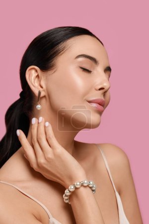Photo for Young woman wearing elegant pearl jewelry on pink background - Royalty Free Image