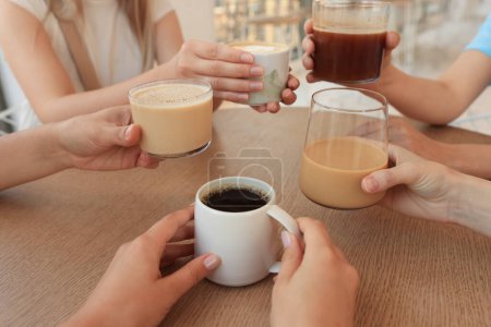 Freunde trinken Kaffee am Holztisch im Café, Nahaufnahme
