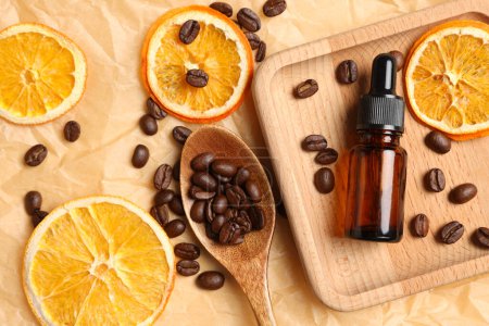 Foto de Composición plana con botella de producto cosmético orgánico, granos de café y rodajas de naranja secas sobre papel pergamino - Imagen libre de derechos