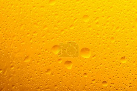 Téléchargez les photos : Glass of tasty cold beer with condensation drops as background, closeup - en image libre de droit