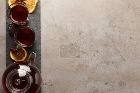 Téléchargez les photos : Assiette en ardoise avec verres de thé turc traditionnel dans des supports vintage, casserole, orange séchée et anis sur table gris clair, vue sur le dessus. Espace pour le texte - en image libre de droit