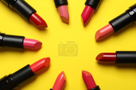 Frame of bright lipsticks on yellow background, flat lay. Space for text Poster 620011840