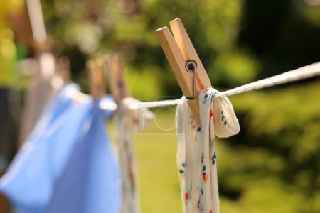 Saubere Wäsche trocknen im Garten, Nahaufnahme. Wäscheklammern im Fokus
