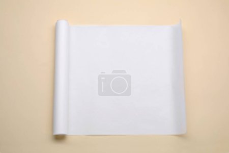 Téléchargez les photos : Rouleau de papier cuisson sur fond beige, vue de dessus - en image libre de droit