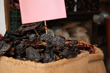 Photo pour Pile de chiles d'ancre noires séchées en toile de jute, gros plan - image libre de droit