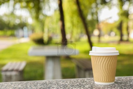 Photo for Paper cup on parapet in park, space for text. Coffee to go - Royalty Free Image