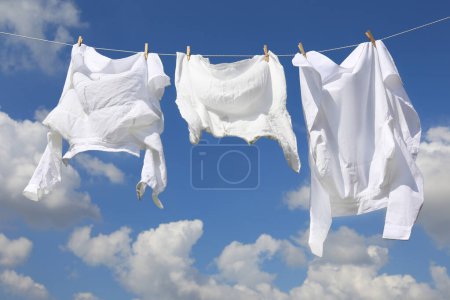 Saubere Kleidung hängt an der Wäscheleine gegen den Himmel. Wäsche trocknen