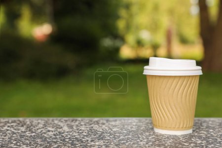 Photo for Paper cup on parapet in park, space for text. Coffee to go - Royalty Free Image