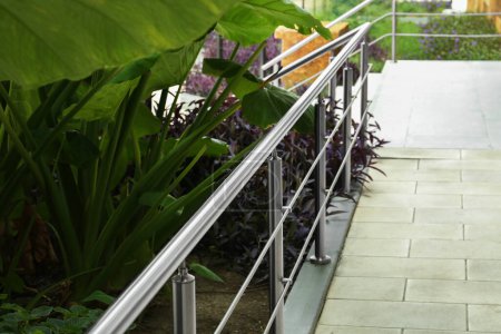 Photo for Metal handrail and plants growing outdoors. Exterior design - Royalty Free Image