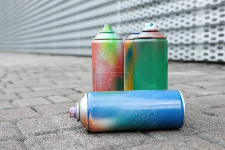 Photo for Used cans of spray paints on pavement, closeup - Royalty Free Image