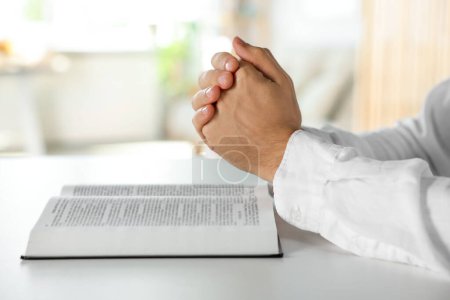 Foto de Hombre con la Biblia rezando en la mesa blanca en el interior, primer plano - Imagen libre de derechos