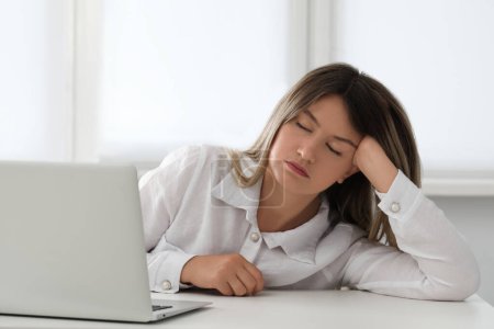 Photo for Tired young woman sleeping at workplace in office - Royalty Free Image