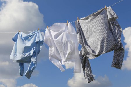 Ropa limpia colgando de la línea de lavado contra el cielo. Secado de ropa