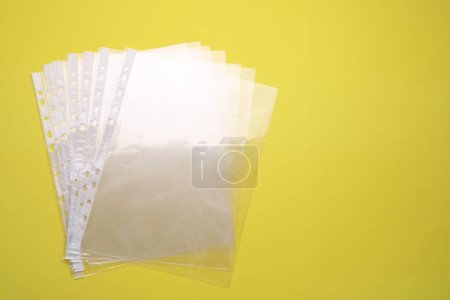 Empty punched pockets on yellow background, flat lay. Space for text