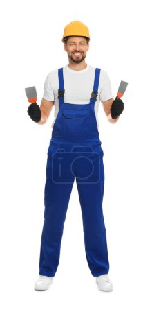 Téléchargez les photos : Travailleur professionnel avec des couteaux à mastic en chapeau dur sur fond blanc - en image libre de droit
