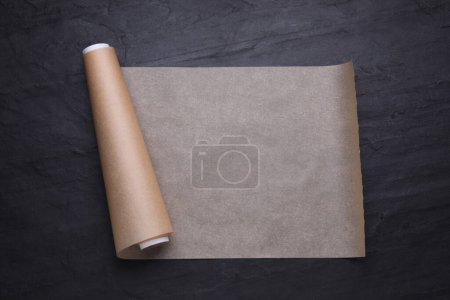 Téléchargez les photos : Rouleau de papier cuisson sur table noire, vue de dessus - en image libre de droit